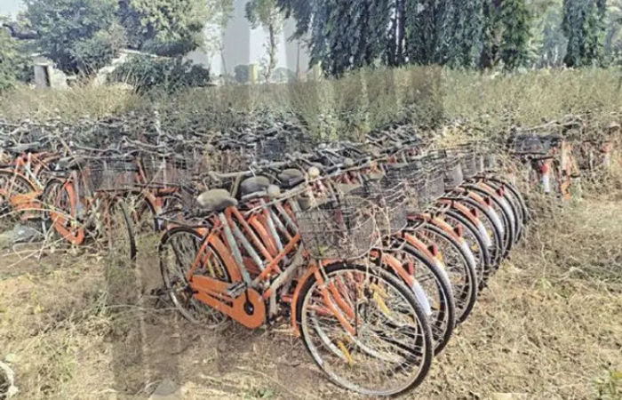 Yet another scam of the state government scheme has sparked a stir where over 14 districts of Gujarat, thousands of cycles purchased under the Saraswati Sadhana Yojana remain undistributed.  These bicycles are lying in a deteriorated state, yet the government is preparing to issue new tenders for purchasing more cycles.  Allegations are made that the BJP government’s schemes are increasingly being perceived as scams.   There are accusations of corruption worth ₹8.5 crore in the procurement of cycles under the Saraswati Sadhana Yojana. The investigation file into this matter has reportedly been delayed as it may implicate several senior officials and leaders.  In 2023-24, Gujarat Chief Minister Bhupendra Patel launched the Namo Lakshmi and Namo Saraswati Vigyan Sadhna schemes. The scheme aimed to distribute cycles to girls from poor families belonging to SC, ST, and OBC communities by June 2023.  However, the process faced delays, including in the tendering stage. The delays were attributed to modifications in tender rules to favour specific companies.  Moreover, the state decided to purchase cycles from a particular company at ₹500 more per unit than the rates in other states. A total of 1.70 lakh cycles were procured.  If ₹500 extra is calculated per cycle, the state government paid ₹8.5 crore more to the cycle company.  Quality control inspections conducted in April 2024 at the Quality Control Center in Gandhinagar revealed that the cycles were of substandard quality, did not meet specifications, and failed to comply with ISI standards.  Despite blatant violations of tender conditions, the procurement proceeded. Notably, GREMCO had raised objections during the tendering process, pointing out that the rates were ₹587 higher than Rajasthan’s and ₹425 higher than West Bengal’s, yet no clarification has been provided on this issue.  Even after a letter was written to cancel the bid, the government did not cancel it and instead awarded the order to the same company. In districts like Ankleshwar, Kheda, Chhota Udepur, Dhanera, Vadodara, Narmada, Rajpipla, Banaskantha, Botad, Anand, Surendranagar, Jamnagar, Dahod, Bharuch, Una, Gir Somnath, Panchmahal, and Morbi thousands of cycles remain undistributed and are in a state of disrepair.  Reports suggest that the government is planning to repaint and refurbish these bicycles before distributing them to beneficiaries.  Over four months have passed since the academic year began, yet the girls have not received their cycles.   Demands have been raised to conduct a quality check on the bicycles, and if tender conditions have been violated, action should be taken against both the bicycle company and the responsible officials. A fair and transparent investigation into the bicycle procurement scam is being demanded.